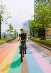 Man fietst over regenboogfietspad in Utrecht